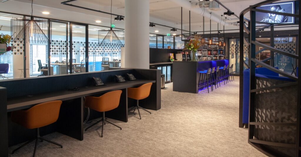 Modern ingericht kantoor met werkplekken, bar en zithoeken op de Amsterdamse Zuidas.