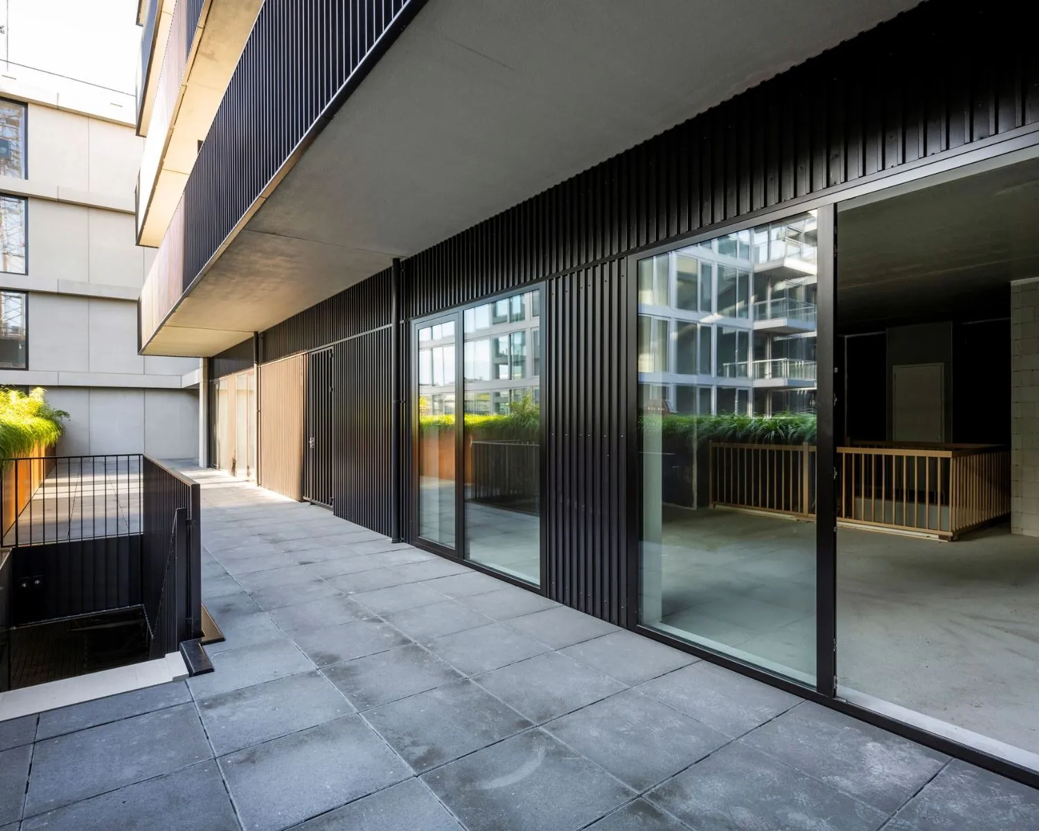 Moderne kantoorruimte met glazen schuifdeuren en betegeld terras aan de Oostenburgermiddenstraat in Amsterdam.