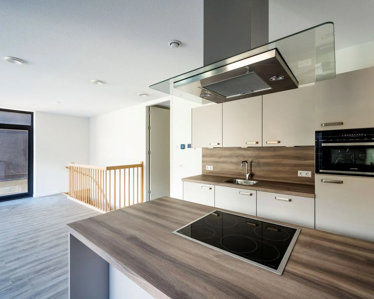 Moderne open keuken met inductiekookplaat en ingebouwde oven in kantoorpand aan de Oostenburgermiddenstraat 123 in Amsterdam.