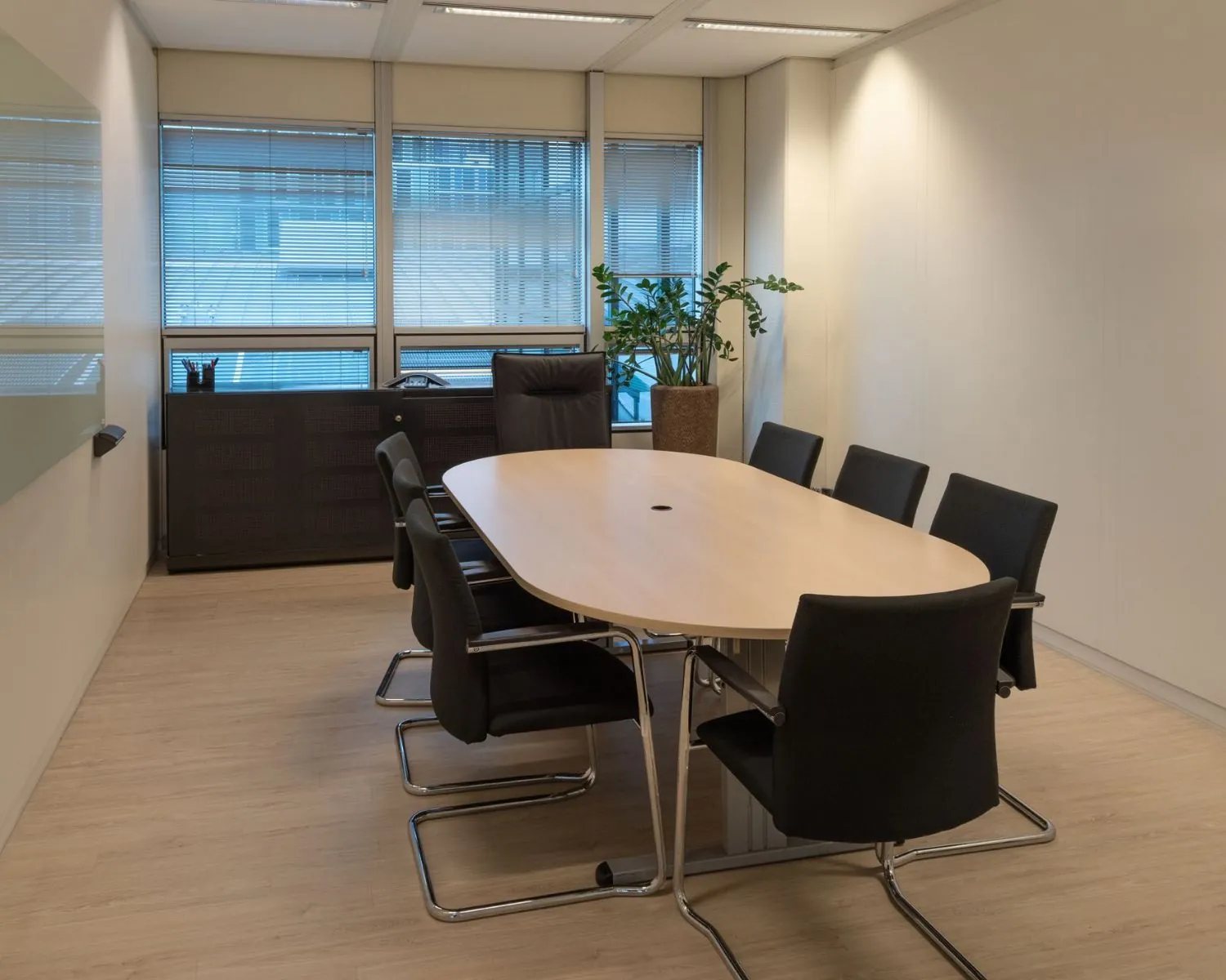 Vergaderruimte met ovale tafel en zes stoelen in een modern kantoor aan de Strawinskylaan in Amsterdam Zuidas.