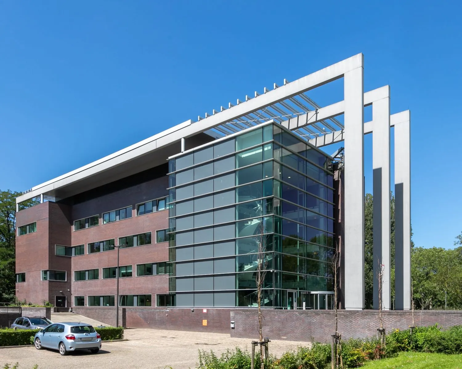 Modern kantoorgebouw aan de Bavincklaan 7 in Amstelveen met glazen gevel en opvallende betonnen zuilen.