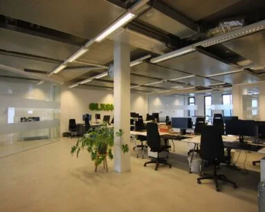 Moderne, open kantoorruimte met werkplekken en glazen vergaderruimte aan de Koivistokade 54 in Amsterdam.