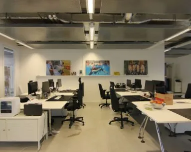 Moderne kantoorruimte aan de Koivistokade 54 in Amsterdam met meerdere werkplekken, computers en wanddecoratie.