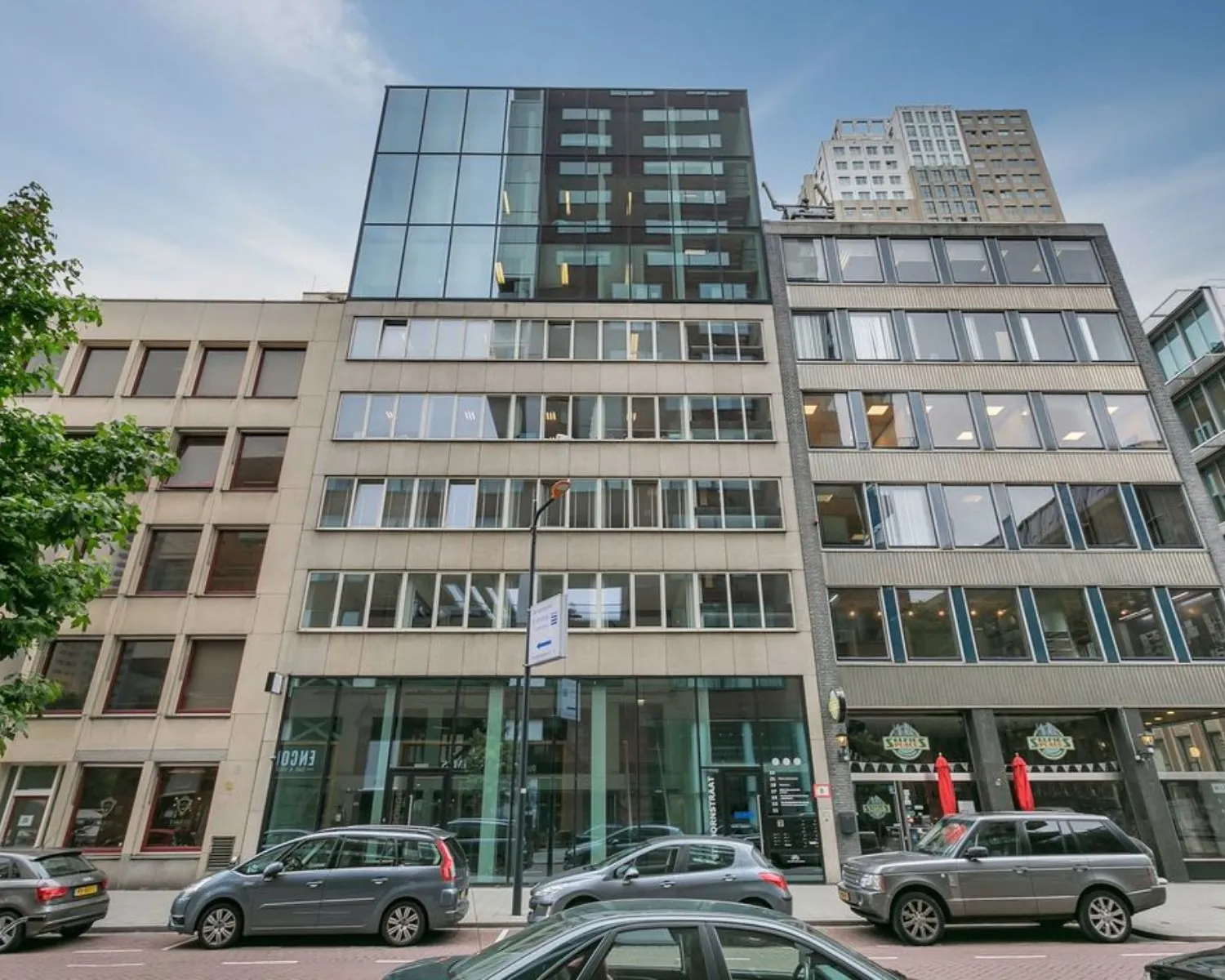 Voorgevel van een modern kantoorpand aan de Posthoornstraat in Rotterdam met geparkeerde auto's voor de ingang.
