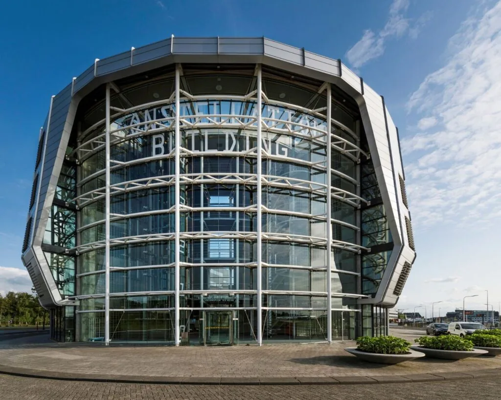 Moderne glazen kantoorgebouw aan het Stationsplein 416 in Schiphol met opvallende ronde gevel.