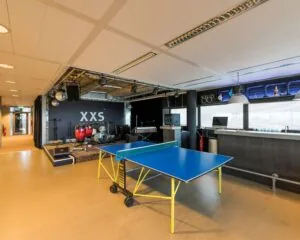 Moderne kantoorruimte aan het Stationsplein 416 in Schiphol met een podium, muziekinstrumenten, tafeltennistafel en bar.