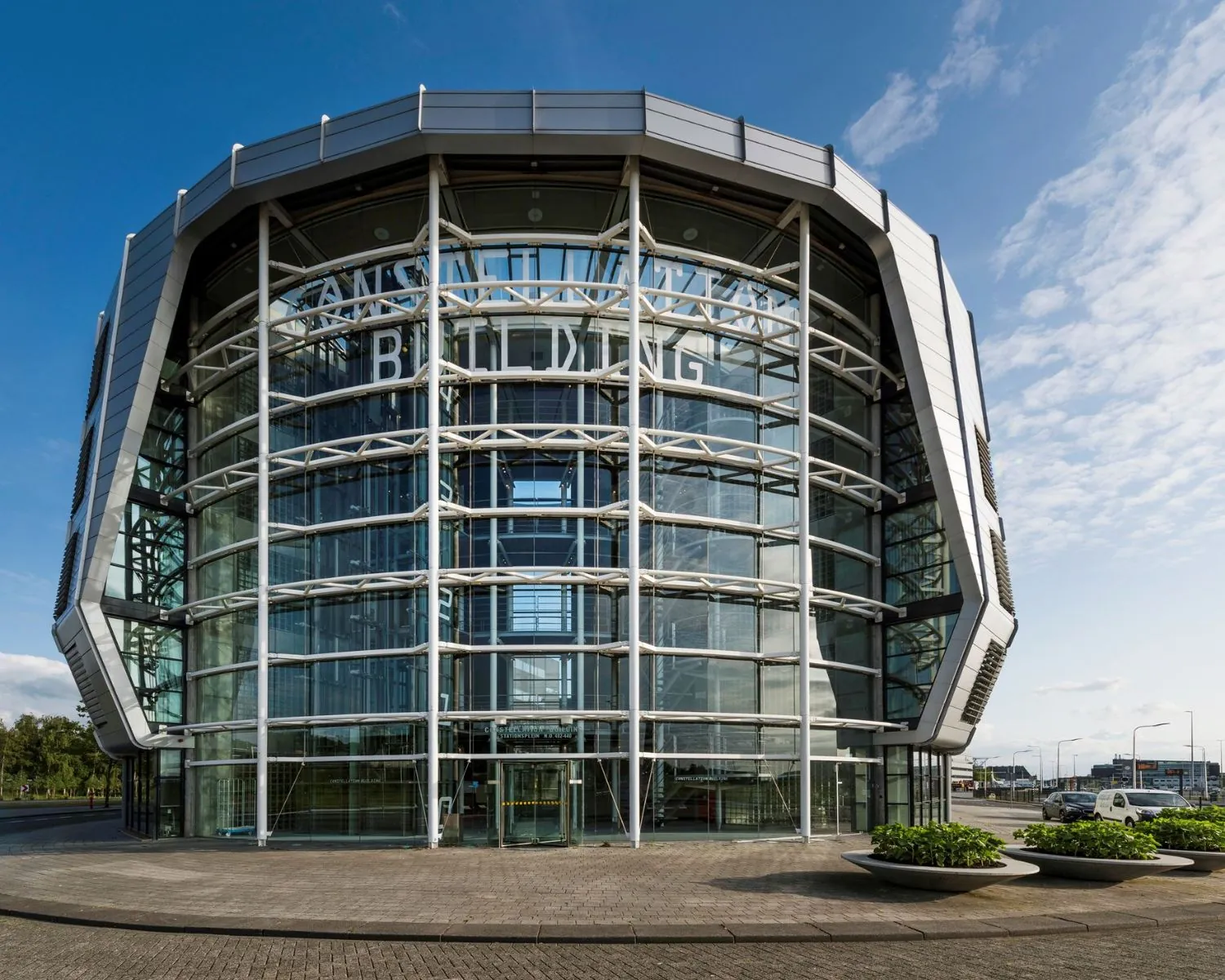 Moderne glazen kantoorgebouw aan het Stationsplein 416 in Schiphol met opvallende ronde gevel.