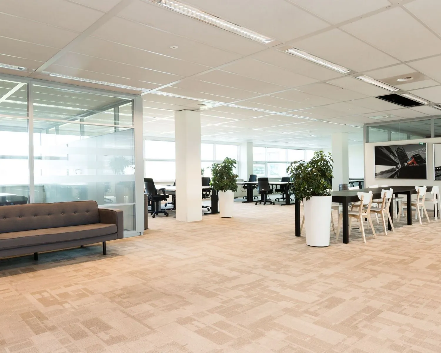 Moderne, open kantoorruimte aan de Capellalaan 65 in Hoofddorp met werkplekken, vergadertafels, planten en veel daglicht.