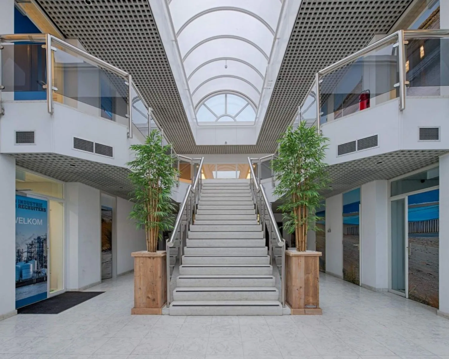 Ruim en licht atrium van een kantoorruimte aan de Curieweg 7 in Spijkenisse, met centrale trap, glazen dak en moderne afwerking.