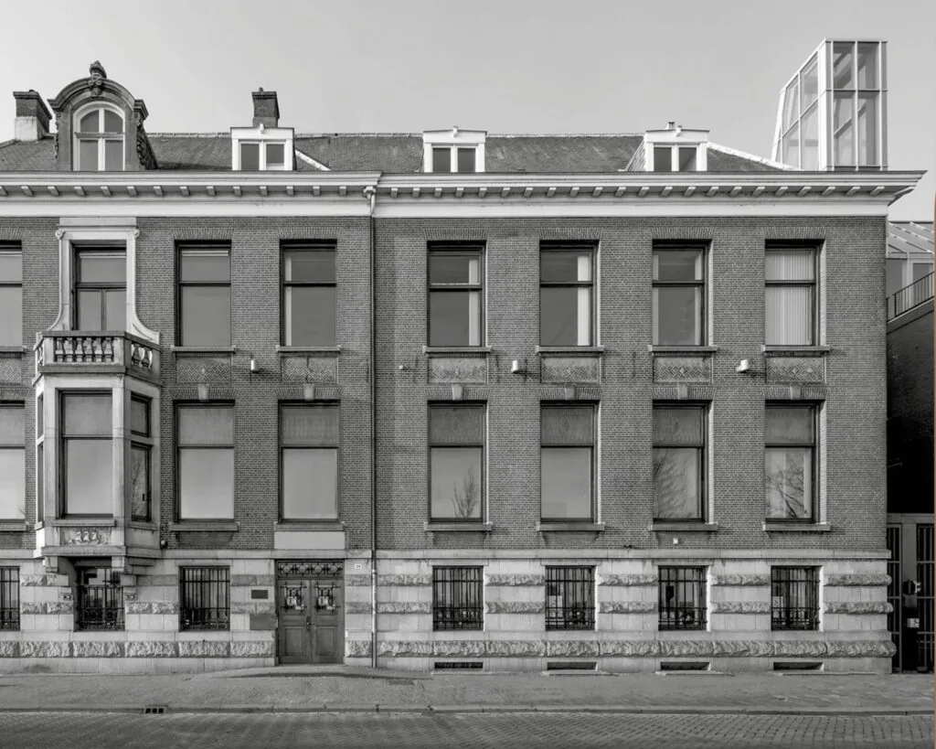 Voorgevel van het kantoorpand aan de De Ruijterkade 139 in Amsterdam met klassieke architectuur en symmetrische raampartijen.