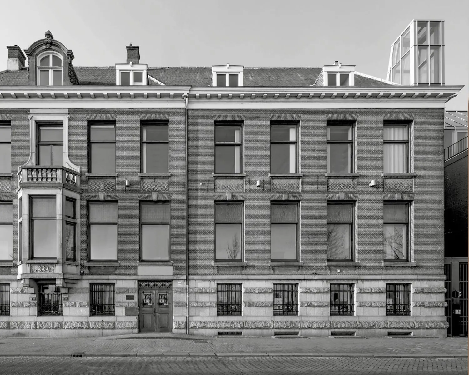 Voorgevel van het kantoorpand aan de De Ruijterkade 139 in Amsterdam met klassieke architectuur en symmetrische raampartijen.
