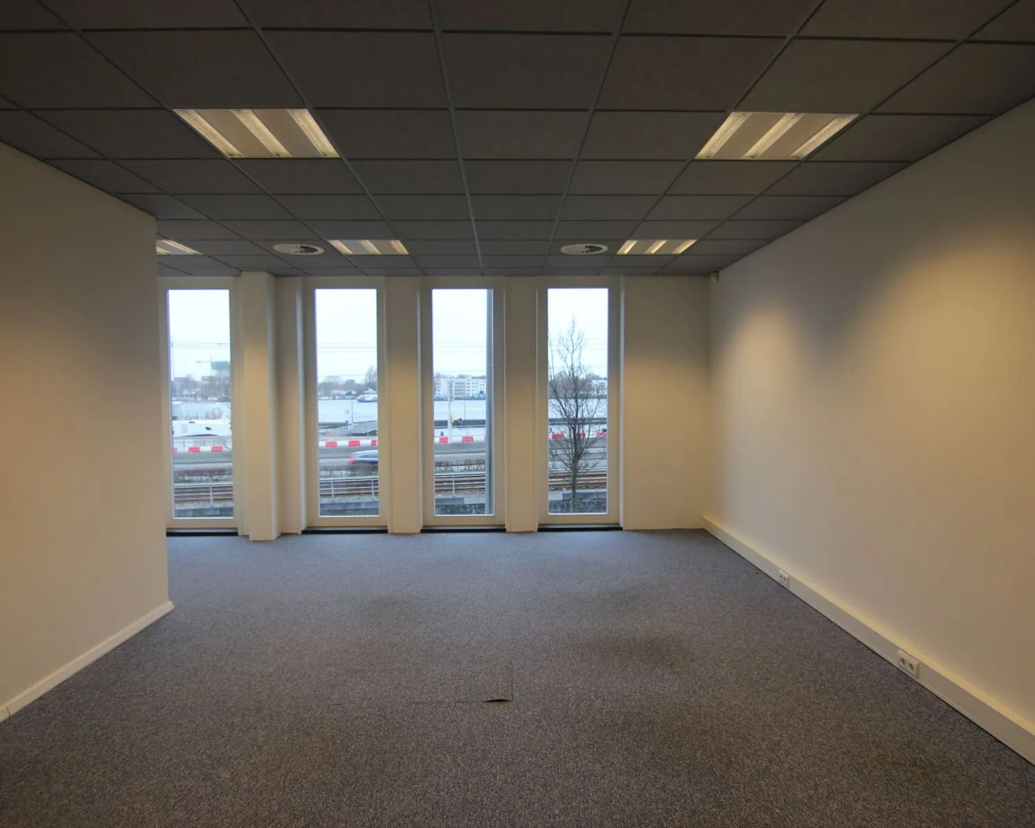 Lege kantoorruimte met grote ramen aan de De Ruijterkade 142 in Amsterdam.