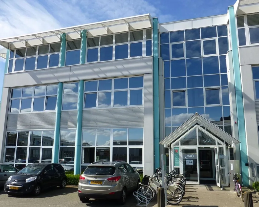 Moderne kantoorruimte aan de Gyroscoopweg 144 in Amsterdam met glazen gevel, fietsenstalling en parkeergelegenheid.