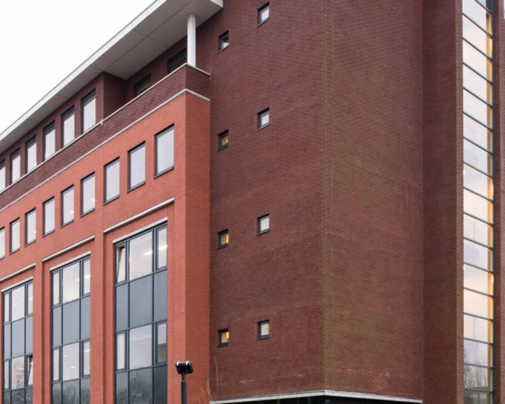 Moderne kantoorgebouw aan de H.J.E. Wenckebachweg 90-108 in Amsterdam met rode bakstenen gevel en grote raamoppervlakken.