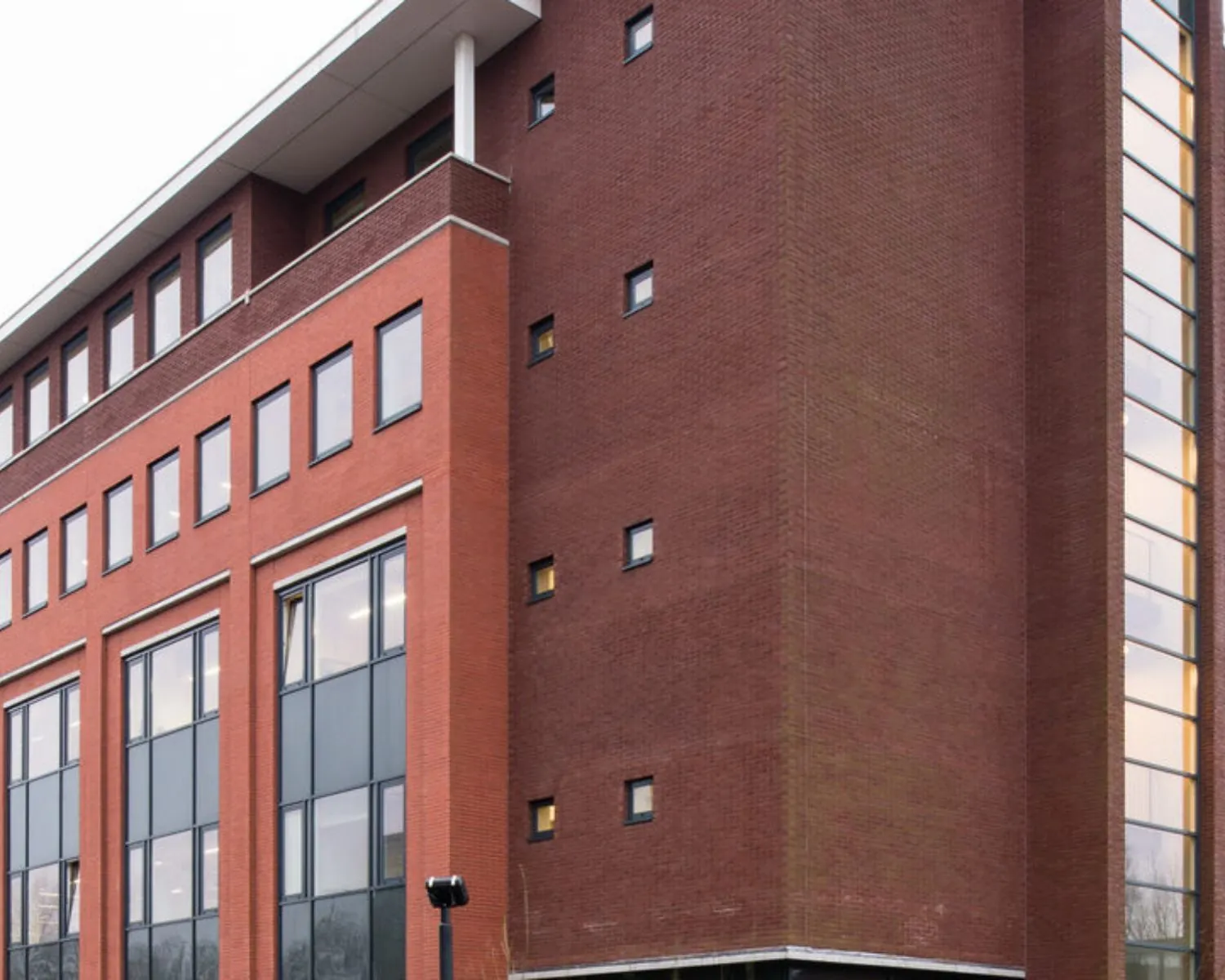 Moderne kantoorgebouw aan de H.J.E. Wenckebachweg 90-108 in Amsterdam met rode bakstenen gevel en grote raamoppervlakken.