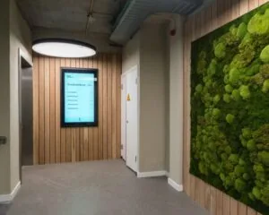 Moderne kantoorhal aan de H.J.E. Wenckebachweg 90-108 in Amsterdam met moswand, lift en digitaal informatiebord.