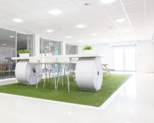 Moderne kantoorruimte aan de Hofmanweg in Haarlem met een creatieve zithoek op kunstgras en een tafel gemaakt van grote papierrollen.