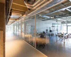 Moderne kantoorruimte aan de Hofmanweg in Haarlem met glazen wanden en industriële afwerking.