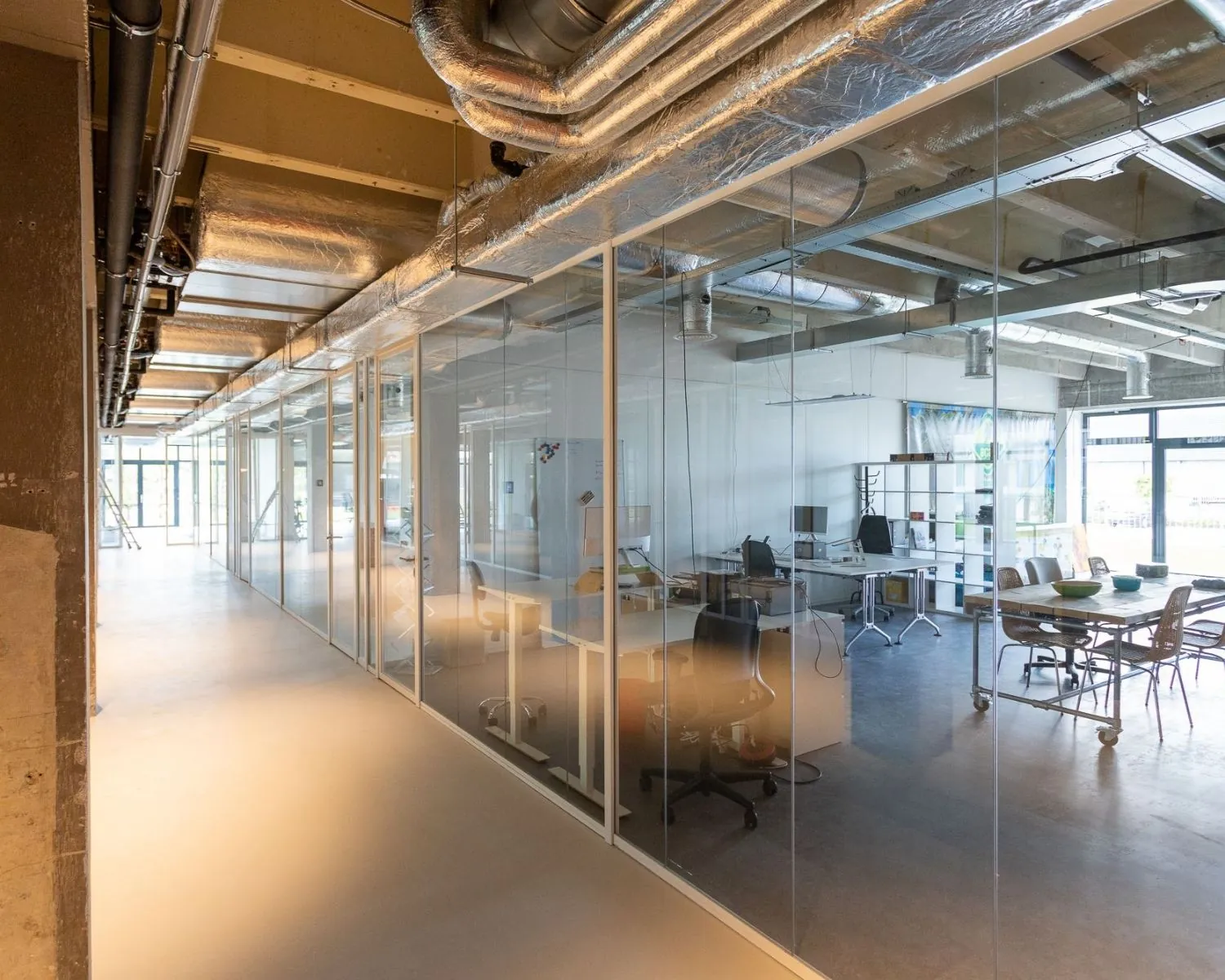 Moderne kantoorruimte aan de Hofmanweg in Haarlem met glazen wanden en industriële afwerking.