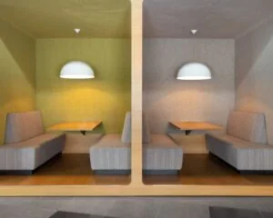 Twee moderne zithoeken met vaste banken en hanglampen in een kantoorruimte aan het Jonkerbosplein 52 in Nijmegen.