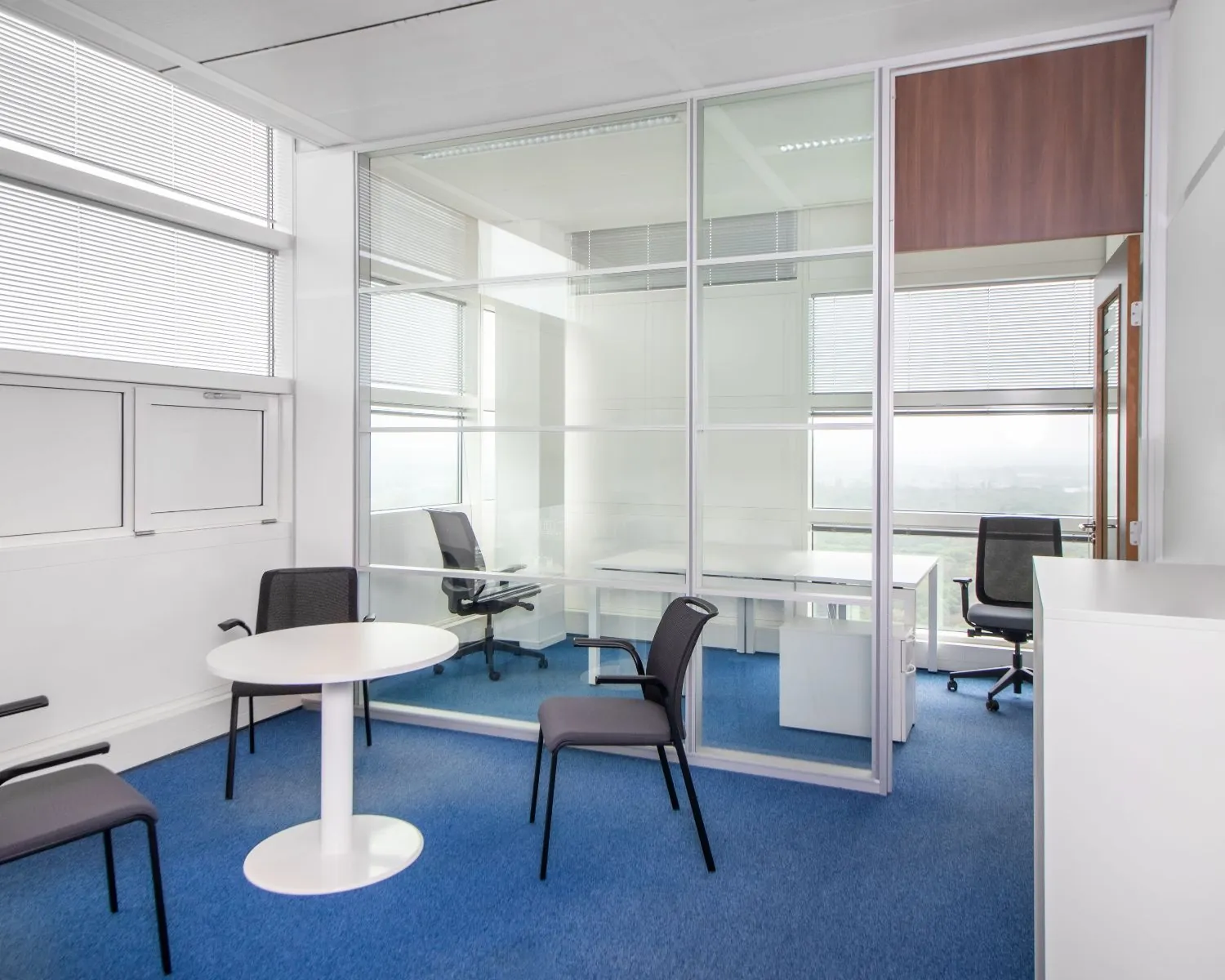 Moderne kantoorruimte met glazen scheidingswand en blauwe vloerbedekking aan het Jonkerbosplein 52 in Nijmegen.