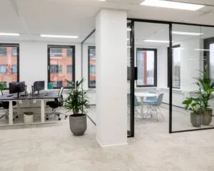 Moderne kantoorruimte aan de Kabelweg 57 in Amsterdam met glazen vergaderruimte, werkplekken en veel natuurlijk licht.
