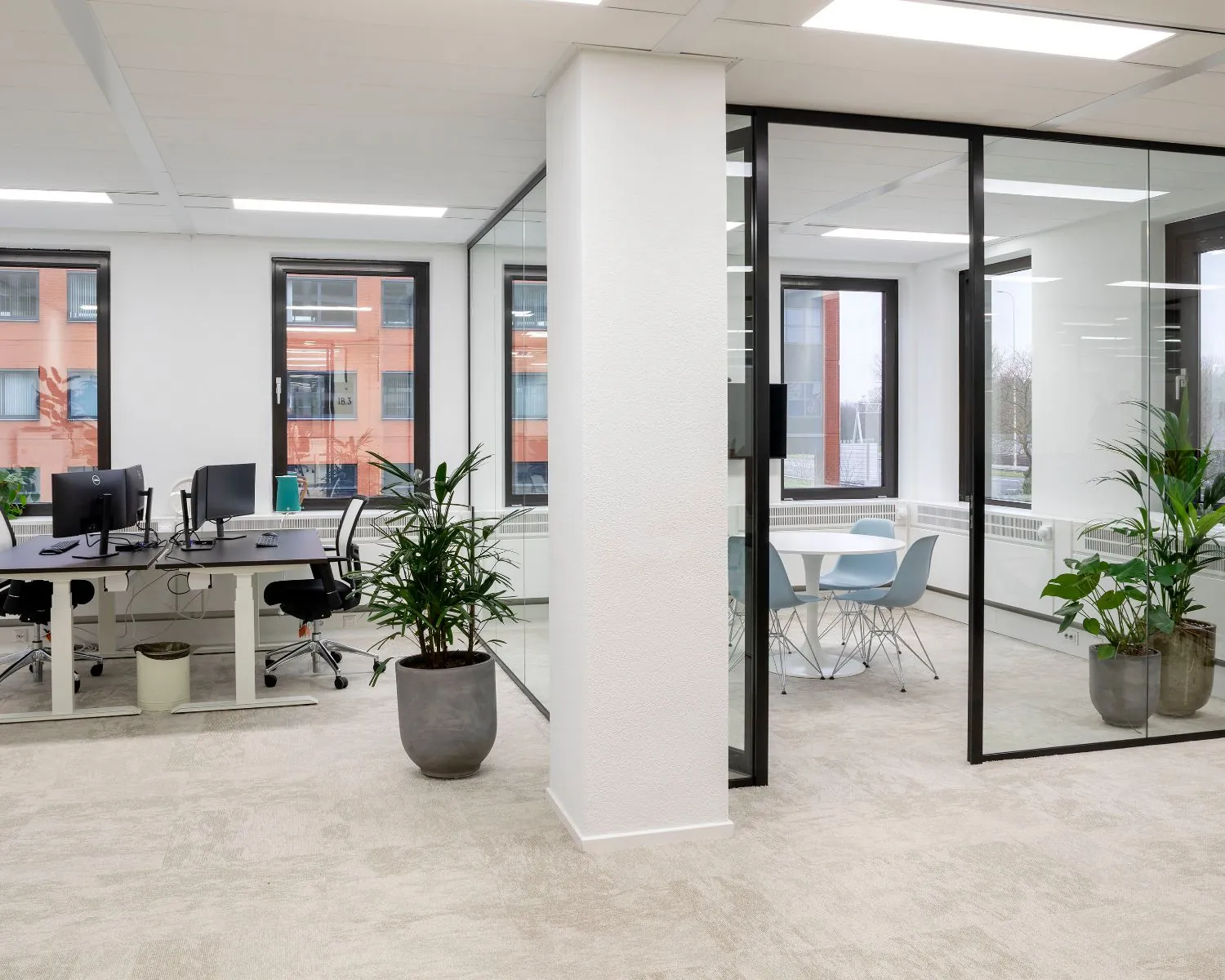 Moderne kantoorruimte aan de Kabelweg 57 in Amsterdam met glazen vergaderruimte, werkplekken en veel natuurlijk licht.