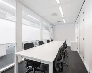 Moderne vergaderruimte met witte tafel en zwarte stoelen in een kantoorpand aan de Kampenringweg 45 in Gouda.
