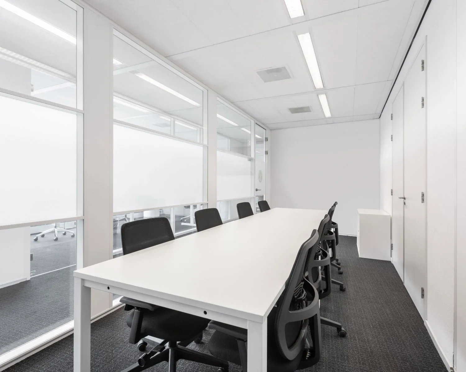 Moderne vergaderruimte met witte tafel en zwarte stoelen in een kantoorpand aan de Kampenringweg 45 in Gouda.