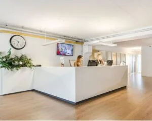Moderne receptiebalie met twee medewerkers in een lichte kantoorruimte aan de Kanaalweg 33 in Capelle aan den IJssel.