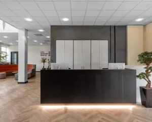 Moderne receptiebalie met strakke zwarte afwerking in de kantoorruimte aan de Louis Braillelaan 80 in Zoetermeer.
