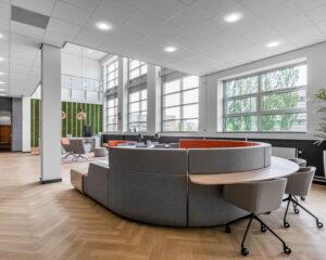 Moderne, ruime kantoorruimte aan de Louis Braillelaan 80 in Zoetermeer met grote ramen, een ronde zithoek en stijlvolle inrichting.