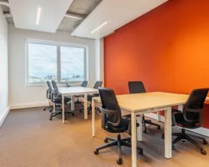 Moderne kantoorruimte met zes bureaus en zwarte bureaustoelen aan de Marten Meesweg 25 in Rotterdam.