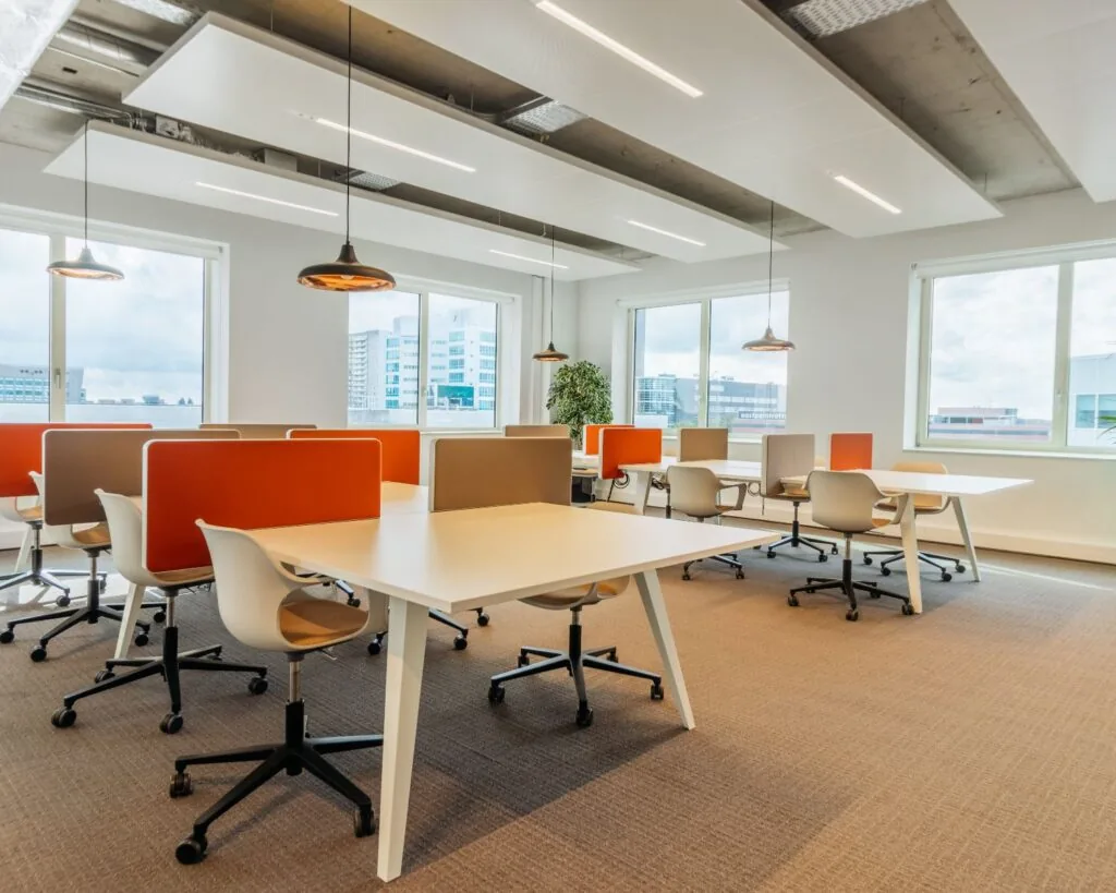 Moderne en lichte kantoorruimte aan de Marten Meesweg 25 in Rotterdam met werkplekken en oranje scheidingswanden.