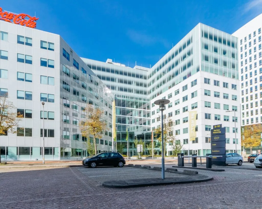Moderne kantoorpanden aan de Marten Meesweg 25 in Rotterdam, met een glazen entree en zichtbare bedrijfsnaamborden.