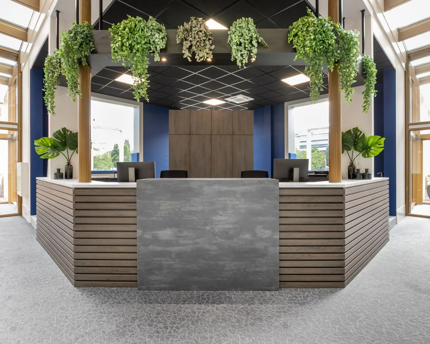 Moderne receptiebalie met houtaccenten en hangplanten in een kantoorruimte aan de Meester BM Teldersstraat 7 in Arnhem.
