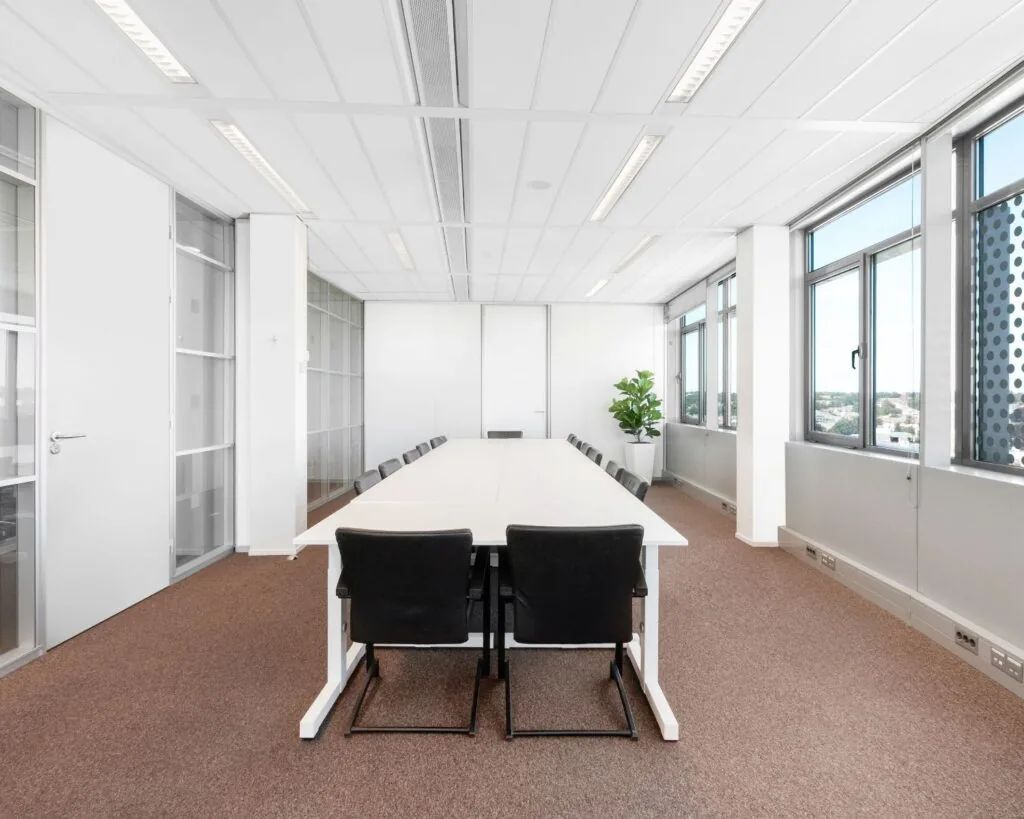 Moderne vergaderruimte met lange tafel en zwart gestoffeerde stoelen in een kantoor aan de Nieuwe Stationsstraat 20 in Arnhem.