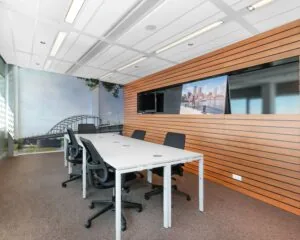 Moderne vergaderruimte aan de Nieuwe Stationsstraat 20 in Arnhem met zes stoelen, wanddecoratie en uitzicht op een brug.