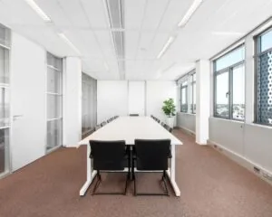 Moderne vergaderruimte met lange tafel en zwart gestoffeerde stoelen in een kantoor aan de Nieuwe Stationsstraat 20 in Arnhem.