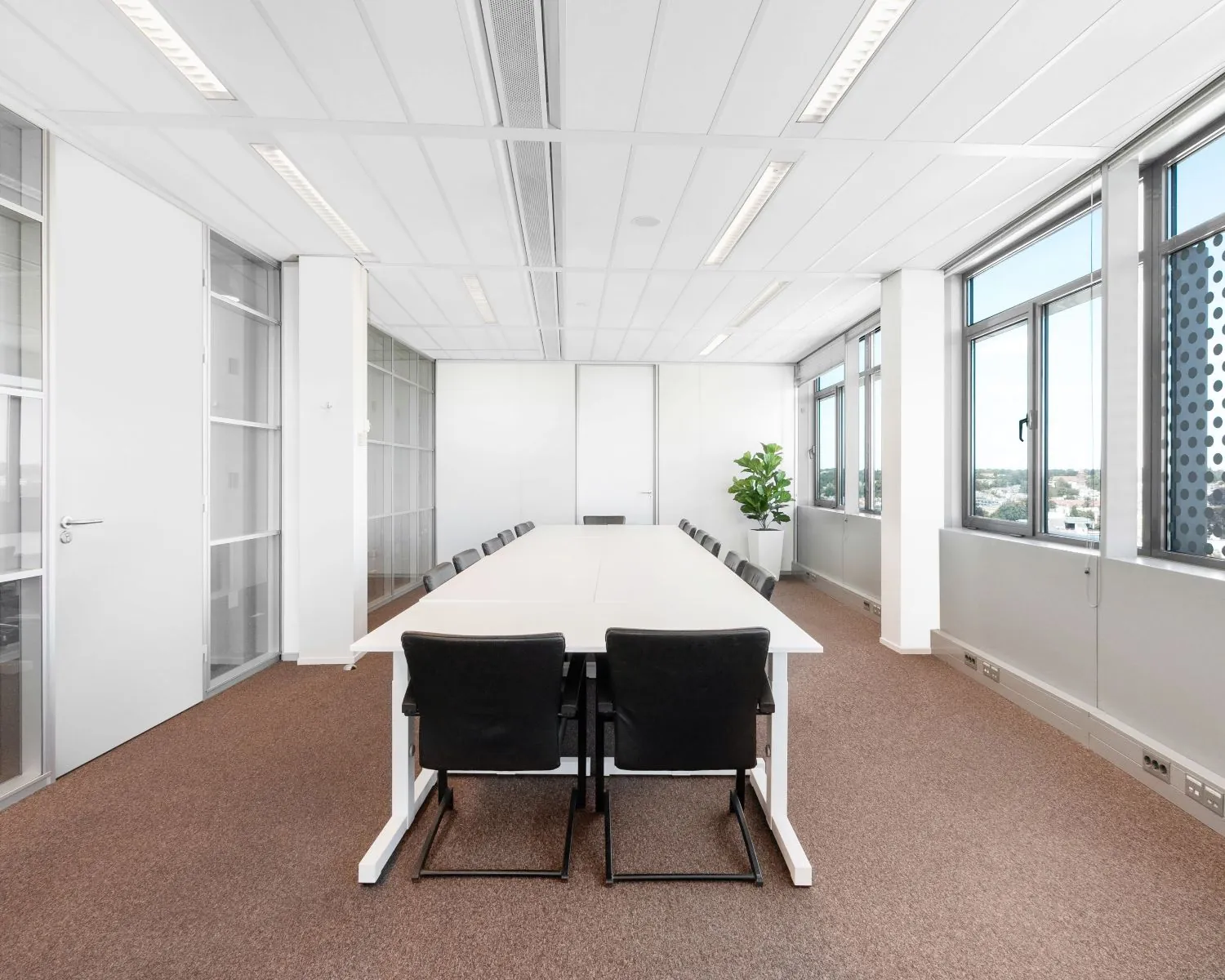 Moderne vergaderruimte met lange tafel en zwart gestoffeerde stoelen in een kantoor aan de Nieuwe Stationsstraat 20 in Arnhem.