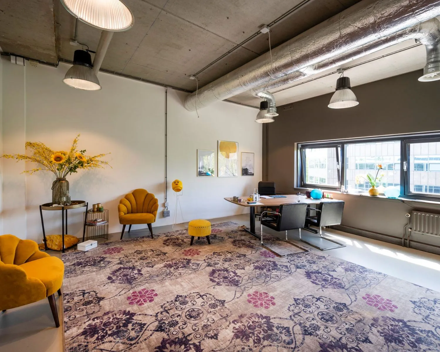 Modern ingerichte kantoorruimte aan de Overschiestraat 180 in Amsterdam met gele fauteuils, een groot vloerkleed en een bureau bij het raam.