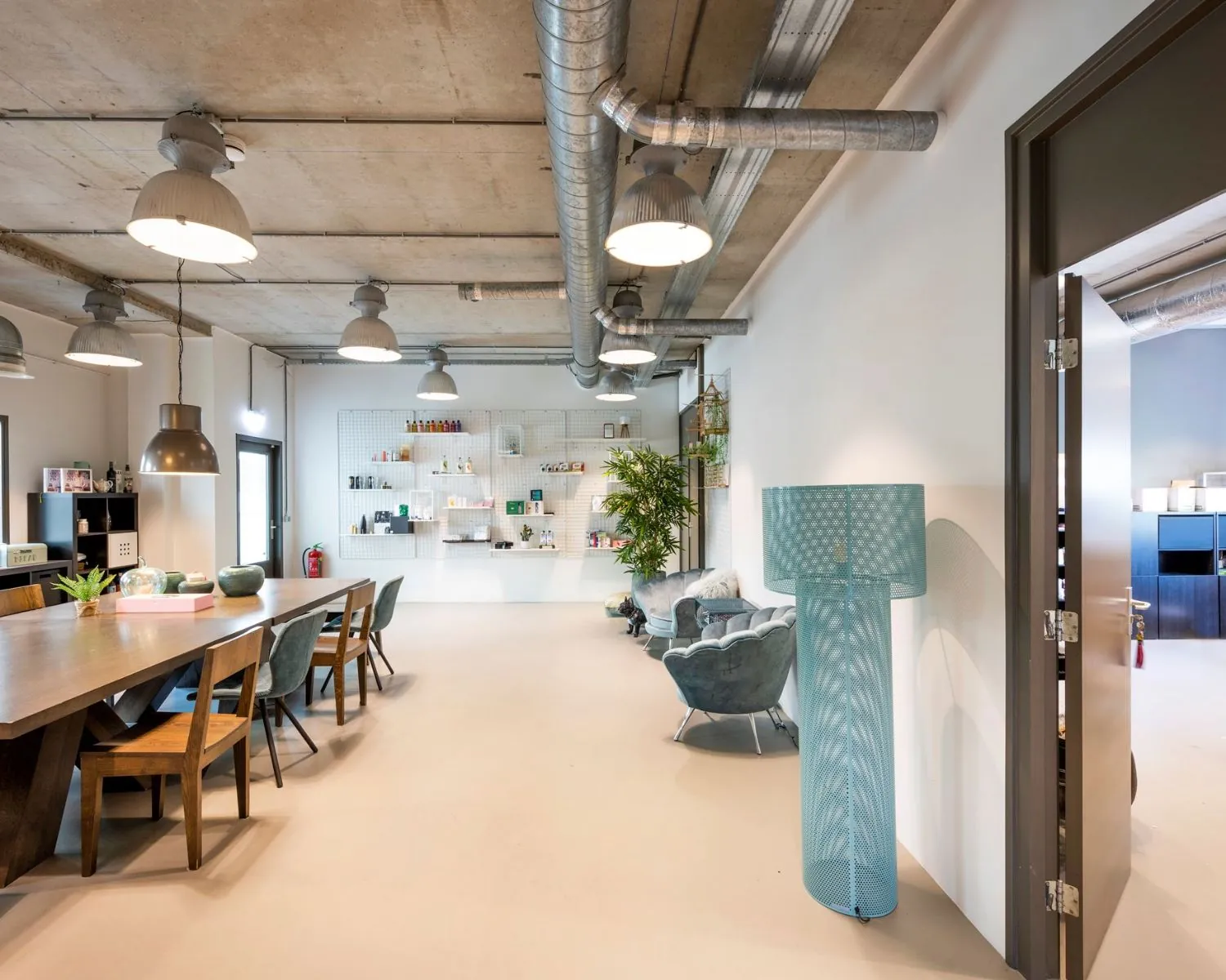 Moderne en lichte kantoorruimte aan de Overschiestraat 180 in Amsterdam met industriële details, een grote vergadertafel en gezellige zithoek.