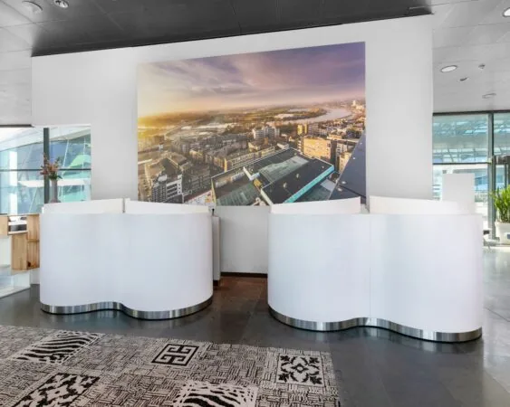 Moderne receptiebalie in de Park Tower Arnhem met grote luchtfoto van de stad aan de muur.