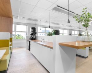 Moderne en lichte kantoorruimte in Pettelaarpark 84 in Den Bosch met een open keuken, zitgelegenheid en planten.