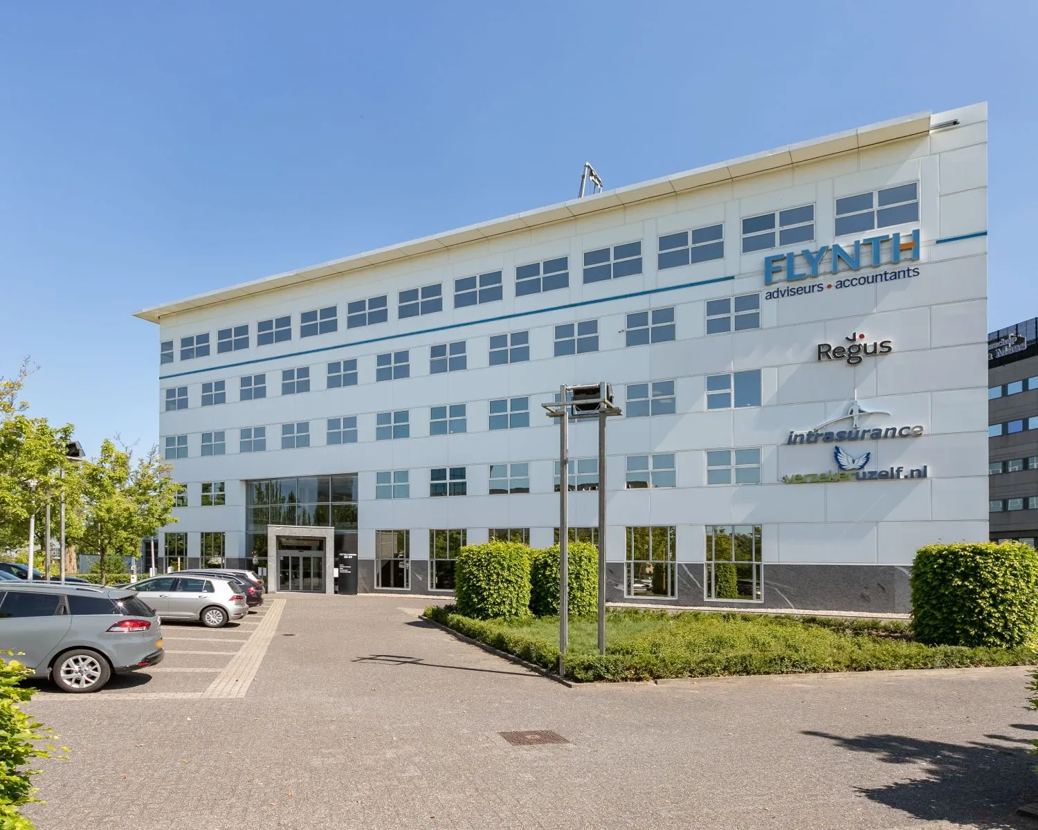 Modern kantoorgebouw Pettelaarpark 84 in Den Bosch met zichtbare bedrijfsnamen en omliggende parkeerplaatsen.