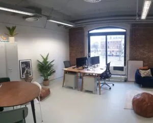 Moderne kantoorruimte aan de Entrepothaven in Rotterdam met werkplekken, een zitgedeelte en uitzicht op de straat.
