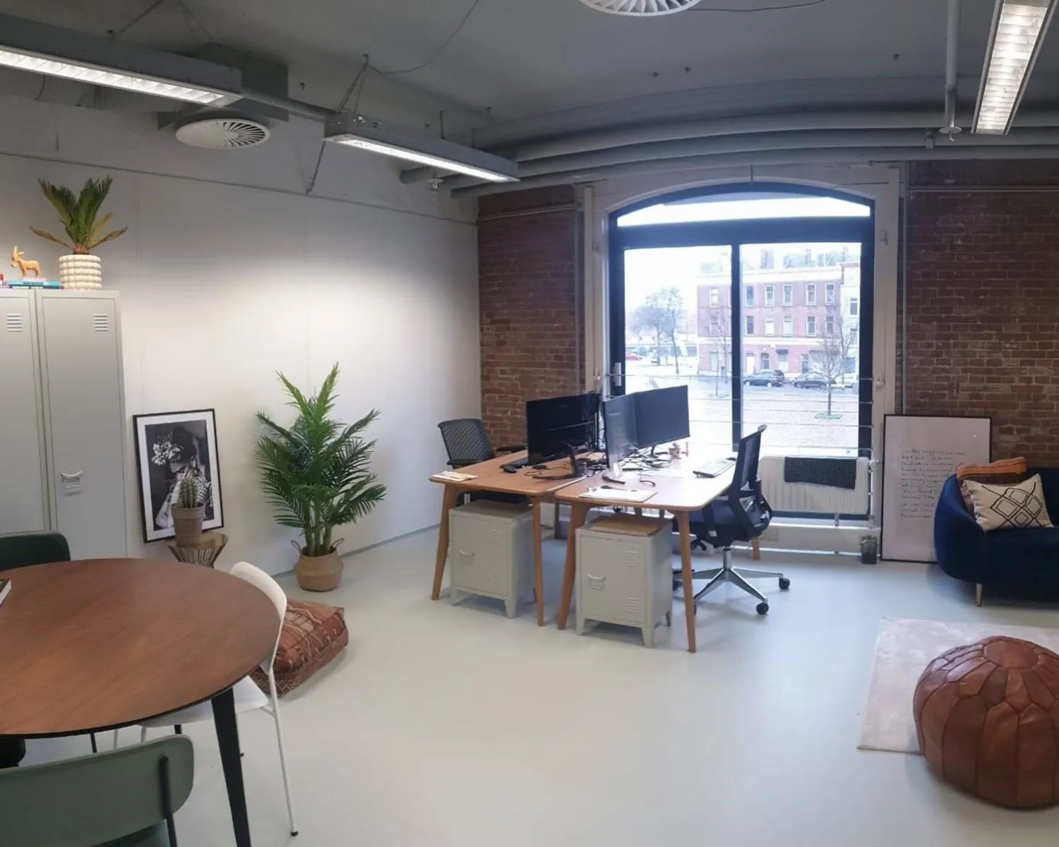 Moderne kantoorruimte aan de Entrepothaven in Rotterdam met werkplekken, een zitgedeelte en uitzicht op de straat.