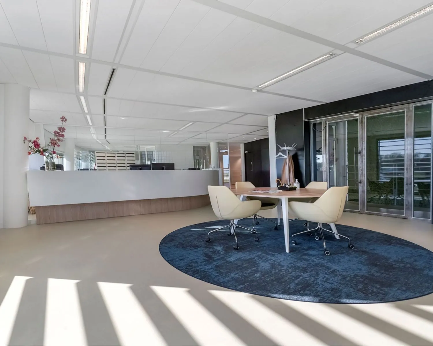 Moderne en lichte kantoorruimte aan het Stationsplein in Schiphol-Oost met een balie, vergadertafel en glazen deuren.