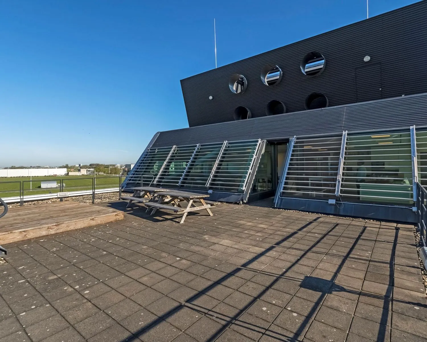 Dakterras met picknicktafels bij een modern kantoorgebouw aan het Stationsplein NO 438 in Schiphol-Oost.