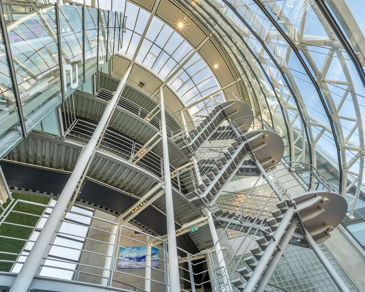 Moderne glazen atriumruimte met metalen trappen in een kantoorgebouw aan het Stationsplein Noord 438 in Schiphol-Oost.